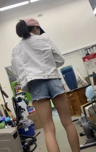 Tight bum hanging out of jean shorts in thrift shop