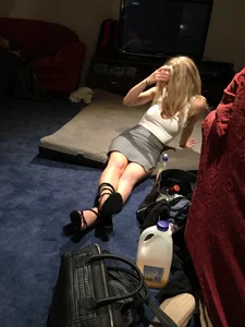 Hot Blonde Girl in High-Heeled Shoes and a Skirt Sitting on the Floor at the Party Creepshots