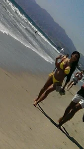 Beach babe with a nice ass and big tits in yellow thong bikini