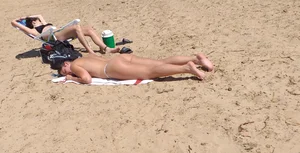 Girl laying out getting sun in a white thong bikini