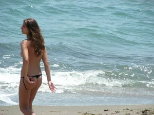 Topless girl with tan lined tits and in a black thong bikini
