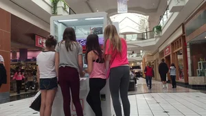 Little blonde teen in grey leggings at the mall with her friends