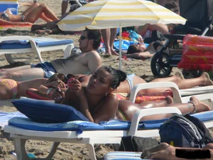 Hot ass topless beach girl with great tits lets her little brother oil up her ass in thong bikini