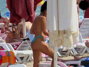 Brunette topless babe with cute tits and a nice ass in a thong bikini