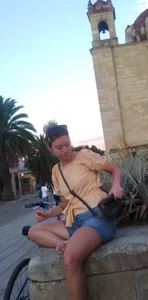 Barefoot Candid Girl in Jean Shorts Sitting With Bent Leg Street Photo