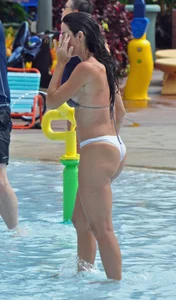 Sexy brunette lady with nice tits at the pool in a semi thong bikini