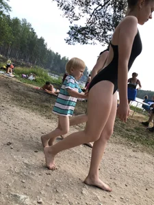 Cute Barefoot Girl in a Black Body Swimsuit Walking on a Road