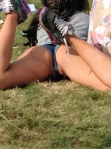 Girl in Mini Shorts Lying on the Grass in a Park With Spread Legs - Lip-Slip Candid Photo