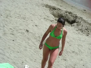 Sexy girl on the beach in her green thong bikini