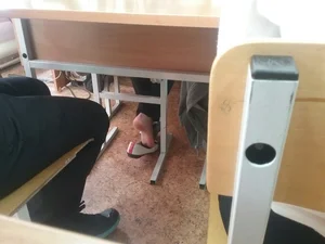 College Teen’s Feet in Flats Shoe Dangle Photo in the Classroom