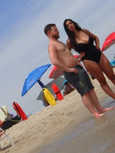 Thick brunette with huge boobs on the beach in black swimsuit