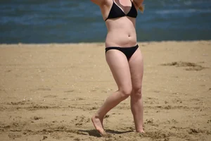 Chunky blonde in a black bikini on the beach