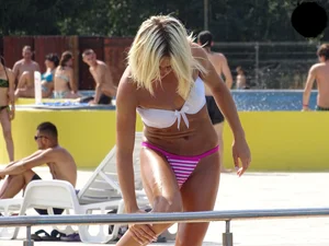 Tanned blonde looking sexy at the pool in thong