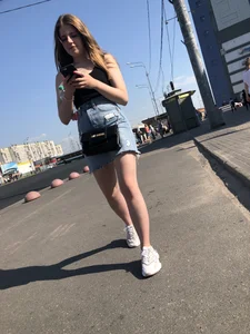 A very cute street candid girl wearing a denim fringed skirt passing by, great legs