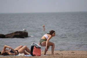 Petite chick with a big booty at the beach in a high waist bikini