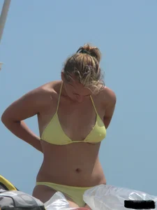 Sexy blonde on the beach in a yellow thong bikini