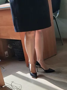 Hot teacher wearing stiletto heels and a skirt in classroom