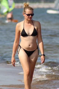 Strawberry blonde sexy mature girl walking the beach in black bikini