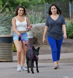 Sexy dog walker in shorts and tank top with friend in blue jeans