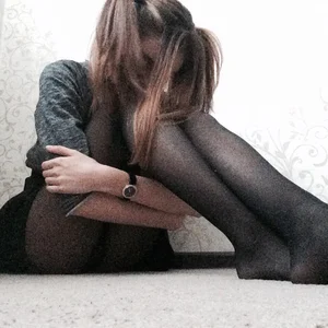 Cute Skinny Girl in a Skirt and Black Pantyhose Sitting on the Floor Selfies