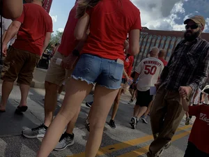 Bunch of girls in various outfits at a Cardinals baseball game