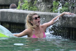 Blonde bikini girl at the pool in pink bikini top with amazing tits