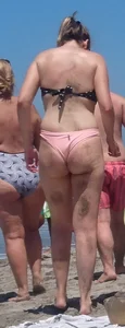 Chunky beach blonde babe in a pink thong bikini