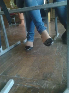 Crossed Legs of a Candid College Girl in Blue Jeans And Flats Under Desk Creepshot in Classroom