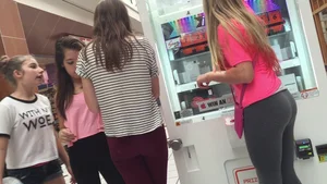 Little blonde teen in grey leggings at the mall with her friends
