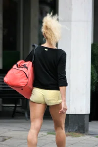 Blonde looking sexy walking in short yellow shorts