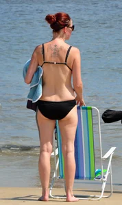 Tattooed redhead milf in a bikini at the beach