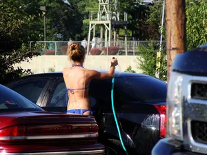Group of cute girls at a car wash in bikinis and shorts