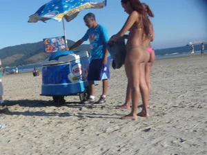 Two tattooed babes on the beach in thong bikinis with nice asses