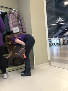 Cute candid shop assistant wearing boots and tight pants