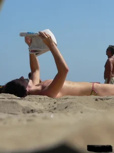 Topless beach milf looking sexy in a tiny g-string bikini