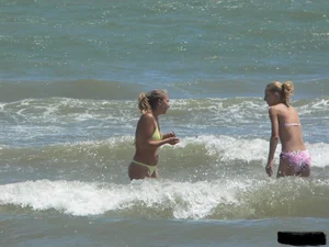 Sexy blonde on the beach in a yellow thong bikini