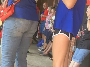 Bunch of girls in various outfits at a Cardinals baseball game