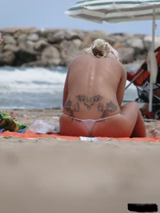 Tattooed blonde with big tits topless and in thong