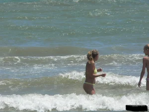 Sexy blonde on the beach in a yellow thong bikini