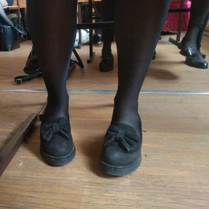 Feet in Black Pantyhose and Flats Under Desk in College Classroom Closeup Photos Collection