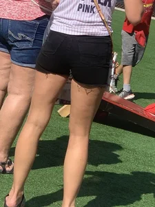 Bunch of girls in various outfits at a Cardinals baseball game