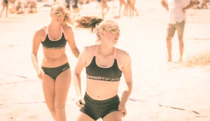 Hot girls playing beach volleyball in bikinis and shorts