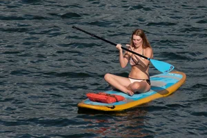 Tall, busty redhead in a skimpy bikini