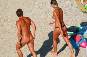 Nudist couple on the beach, girl has amazing tits and nice ass in a thong