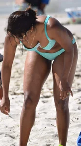 Tanned brunette girl on the beach in a bikini