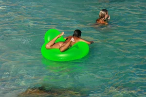 FKK Nudists playing in the water with floater