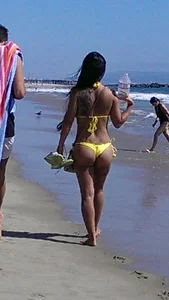 Beach babe with a nice ass and big tits in yellow thong bikini