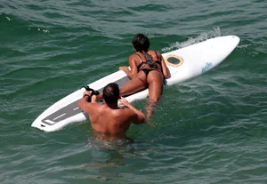 Black girl on the beach in a bikini with an incredible ass while surfing