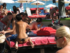 Topless cutie at the beach with a tight little ass in a thong