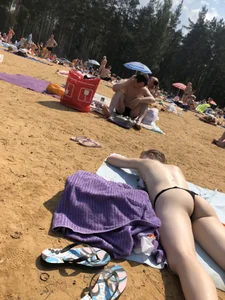 Topless Skinny Girl With Very Pale Skin Lying on a Beach on Her Tummy With Slightly Spread Legs Creepshots Gallery